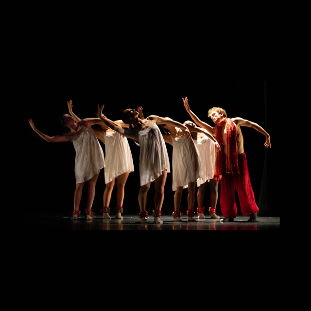 group of people in white with one person in red