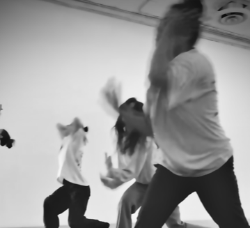 black and white image of dancers moving across the floor