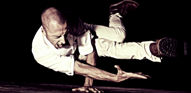 an image of a dancer sideways balancing on their hand in a static pose