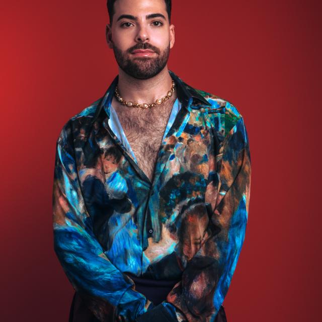 man in animated top in front of red backdrop