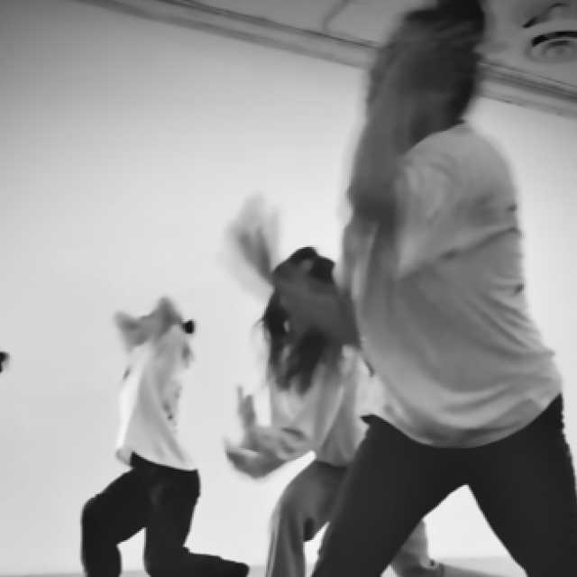 black and white image of dancers moving across the floor